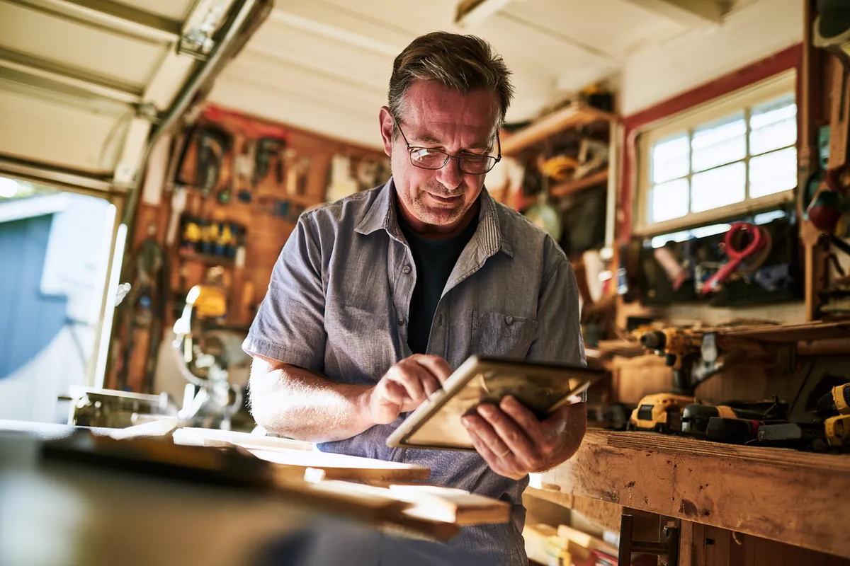 Homeowner planning a repair project on a tablet before requesting an Uplyft Capital personal loan