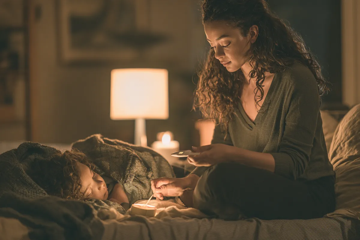 Mother holding a thermometer at her child's bedside, the kind of surprise bill Uplyft Capital readers ask about